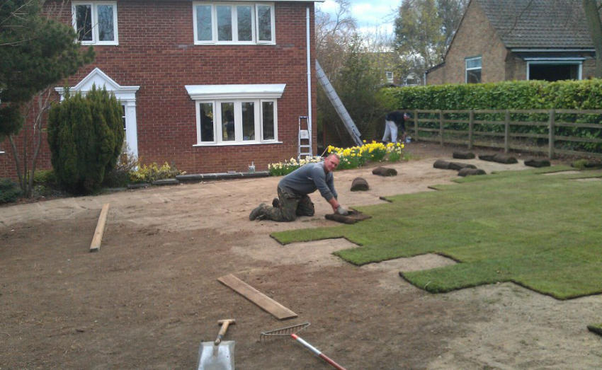 Header image - Gardener laying turf
